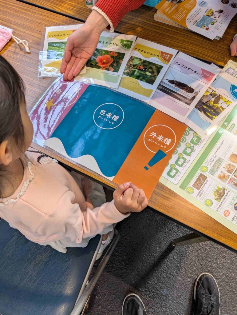 第18回むさしの環境フェスタ2025_遊んで学ぶ”親子体験レポinむさしのエコreゾート_環境政策課計画係_市内の生き物や、外来種について教えてもらう様子